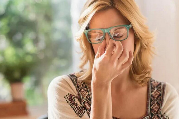 young-woman-pinching-nosebridge-under-glasses young-woman-pinching-nosebridge-under-glasses